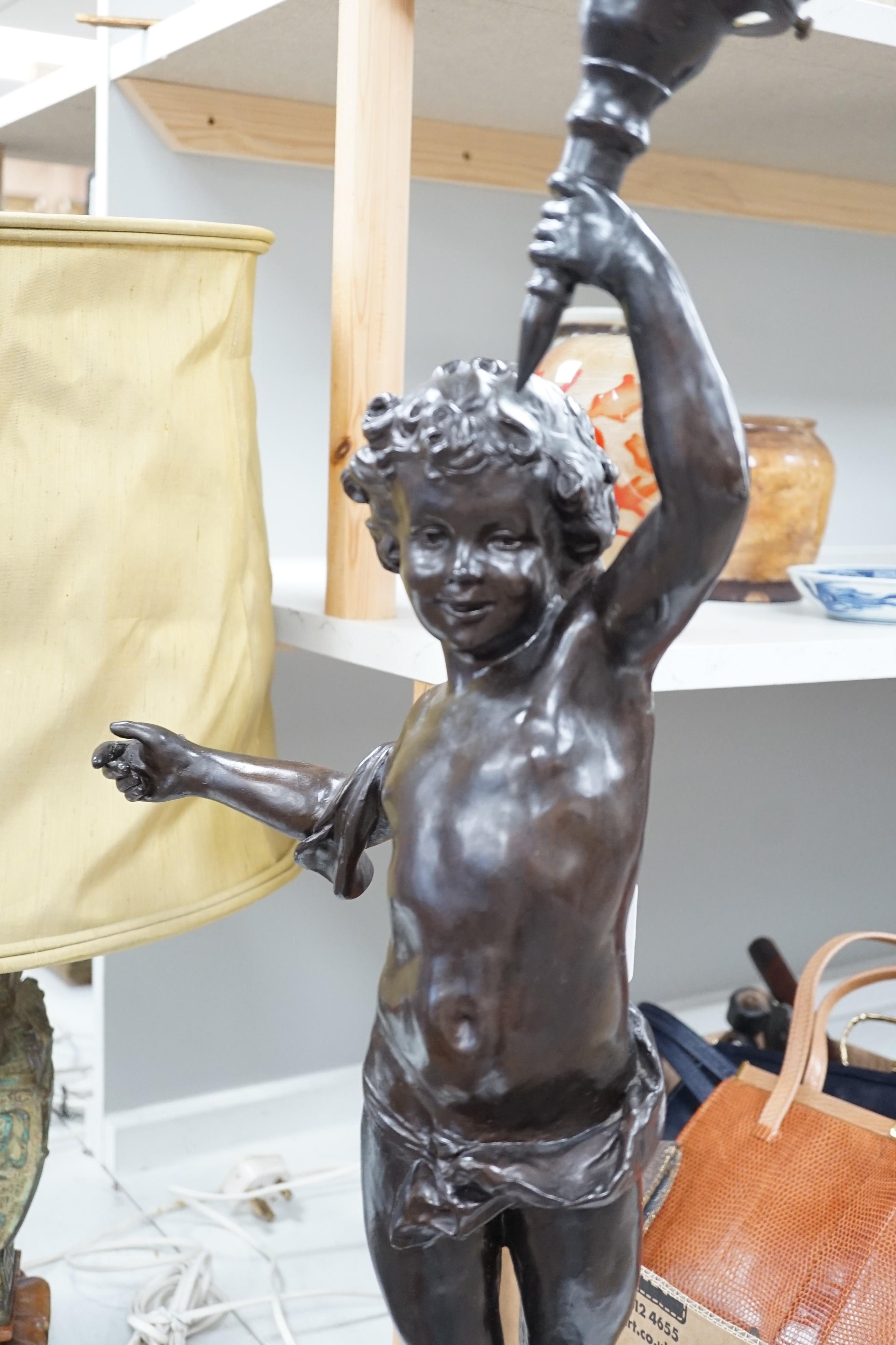A bronzed composition cherub table lamp with frosted glass shade Height 88 cm.